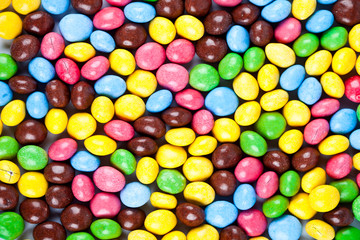 Pile of delicious rainbow colorful chocolate candies background.