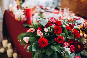boho wedding decor. festive table with burgundy tablecloth. decoration of the hall garland with light bulbs.