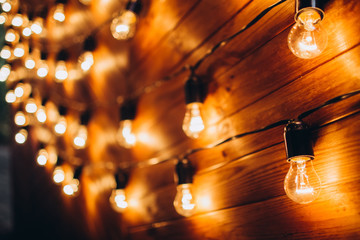 boho wedding decor. festive table with burgundy tablecloth. decoration of the hall garland with light bulbs. © Stanislav