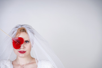 pretty curvy adult woman with short hair wearing long vintage wedding dress with sun style skirt. young caucasian bride with veil on white studio background alone.