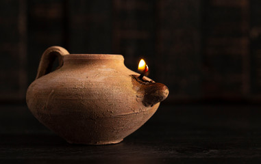 A Lit Handmade Oil Lamp from the Middle East on a Dark Table