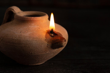 A Lit Handmade Oil Lamp from the Middle East on a Dark Table