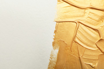 Golden paint brush strokes on white background. Space for text