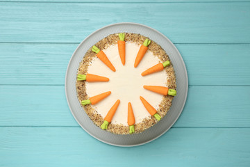 Dish with delicious carrot cake on blue wooden background, top view
