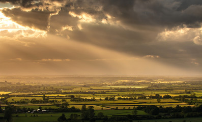 British landscape during sunset with dramatic sky and splash of sunlight