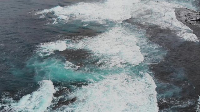 Aerial Drone Azores Portugal waves crashing on rocks tilt up to mountains