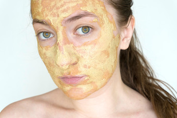 a woman with problem skin care apply a dotted natural mask of green algae on acne on a pimple