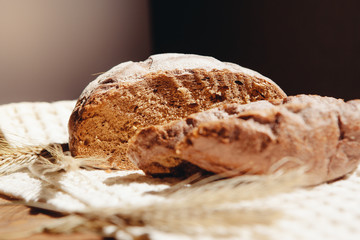 Fresh brown sliced bread with spikelets on table on kitchen, food still life