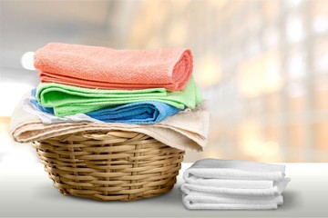 Laundry Basket with colorful towels on background