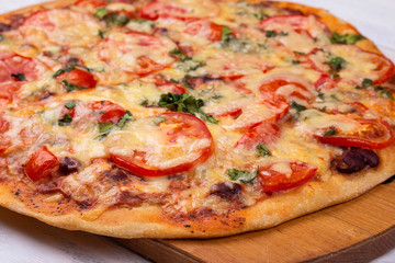 Homemade Italian pizza on wooden tray and white wooden background