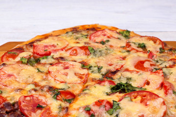 Homemade Italian pizza on wooden tray and white wooden background