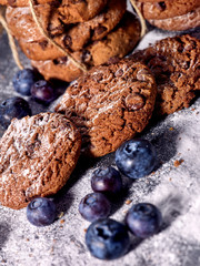 Serving food on slate onto wooden table. Oatmeal cookies biscuit with blueberry on picnic dark tiles countrylike. Chocolate Xmas holiday chip cookies. Perfect product. Serve this dish hot.