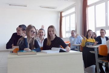 Obraz premium University students listening while Male professor explain lesson to them and interact with them in the classroom.Helping a students during class. 