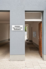 Weisses Schild - Einfahrt freihalten - auf einer Hauswand zwischen Toreinfahrt und Haustür