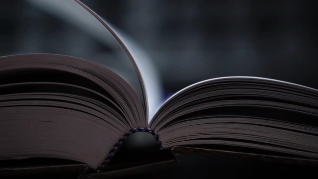 Reading old textbook in university library, read book or relaxing in vintage black background. Reading is complex cognitive process of decoding symbols to derive meaning communication information.