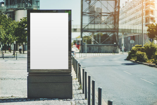 Mockup of the blank information poster in urban settings near the road turn; an empty vertical street banner template on the sidewalk; an outdoor billboard placeholder mock-up on the pavement stone