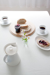 Obraz na płótnie Canvas 白いテーブル　朝食　コーヒーとパン　小花　