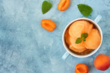 Homemade apricot ice cream , sorbet with ripe apricots and mint leaves. Top view