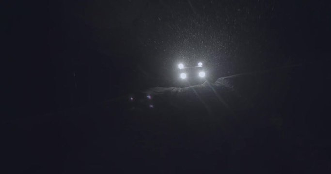 Half-track driving in the night in Jotunheimen in Norway. The half-track has skies in front. Its night and the snow are falling. Filmed on a gimbal in 4k.