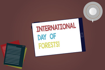 Word writing text International Day Of Forests. Business concept for Natural environment protection celebration Tablet Empty Screen Cup Saucer and Filler Sheets on Blank Color Background