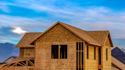 Panorama Exterior of a house under construction against vivid blue sky with clouds