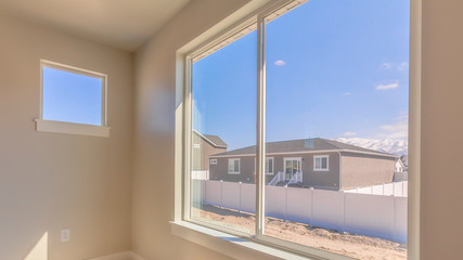 Panorama Room of a new house with a large window overlooking homes mountain and sky