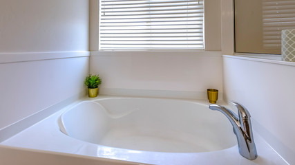 Panorama frame Gleaming white bathtub inside a bathroom with a large mirror on the wall
