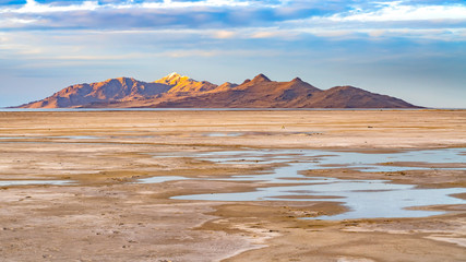 Panorama frame Vast sandy shore of a lake under bright blue sky with thick puffy clouds