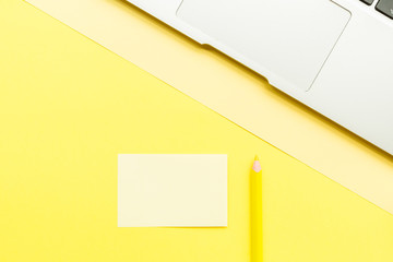 Mockup Blank page with laptop and pencil on yellow background. Top view with copy space for input...