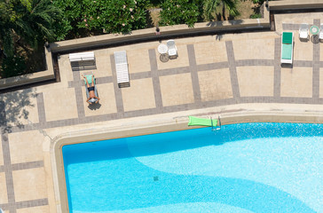 Man relaxing on bed at swimming pool,High angle view.