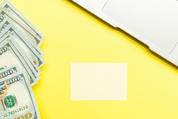 Mockup Blank page with laptop and cash money on yellow background. Top view with copy space for...