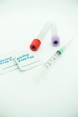 Blood taking kit, Empty syringe with needles, blood container tube and alcohol swab against isolated white background, medical concept