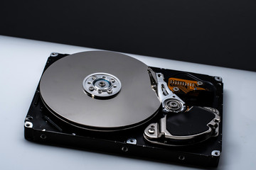 Close up of a Disassembled computer hard drive on white isolated background with reflection