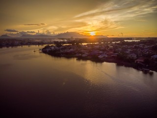 scenic aerial view of Sarawak River during sunset with Gunung (mountain) Serapi at the background © MuhammadFadhli