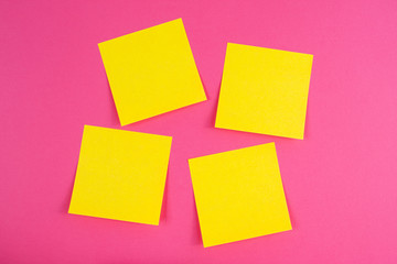 Four yellow paper sticker glued on pink background