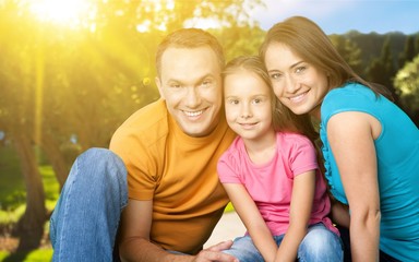Fototapeta premium Happy smiling family with daughter over green trees background