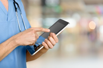Male doctor with stethoscope on blurred hospital background