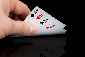 a poker player looks at his cards by raising them on a black table