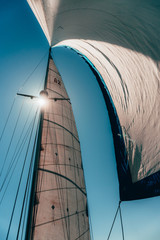 Looking up towards Sailboat Sails with the Bright sun shining through