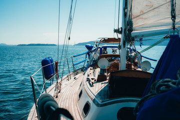 Side profile view of Sailboat while Sailing with Island in the background