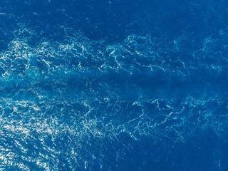 Blue sea background, waves from ship. Top view