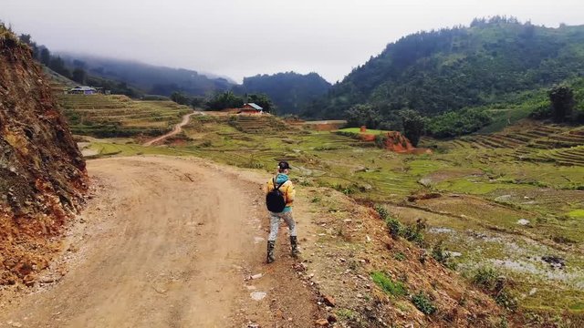A young woman walks along the road among the rice terraces in the village of cat kat near the city of Sapa. Vietnam. 4K move drone