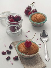 High view of cherry muffins decorated with fresh and dry cherry. Vertical. Selective focus.