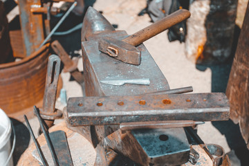 anvil. on it lies a hammer. blacksmith works. close-up.