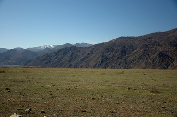 A picturesque fertile valley surrounded by mountains stretching beyond the horizon.
