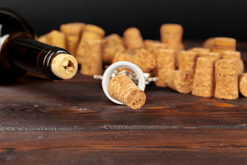 Wine corks with corkscrew on wooden table