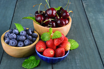 Fresh fruits berries, strawberry, cherries, blueberry on wooden background.
