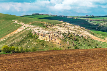 Obraz premium Arable land on green hills in spring landscape
