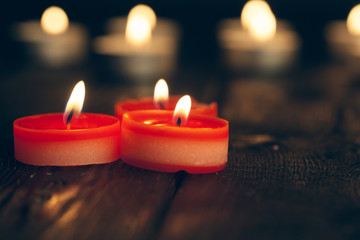 candles burning in darkness over black background. commemoration concept.