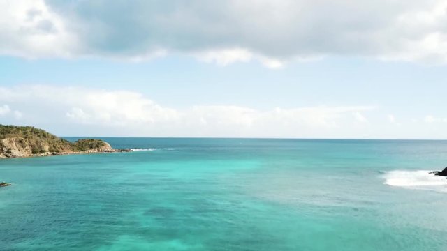 Turquoise Caribbean ocean bay of blue sea waves crashing in remote exotic island harbor on coast of tropical Virgin Island during spring break getaway